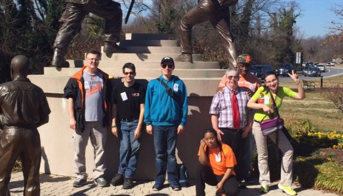 A group of individuals posing outside next to a monument during one of our field trips.